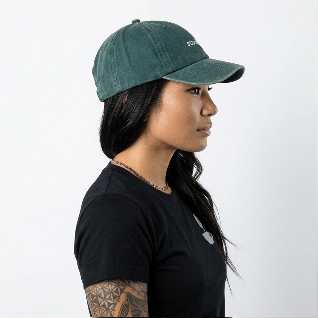 Person wearing a green cap and black shirt on a white background